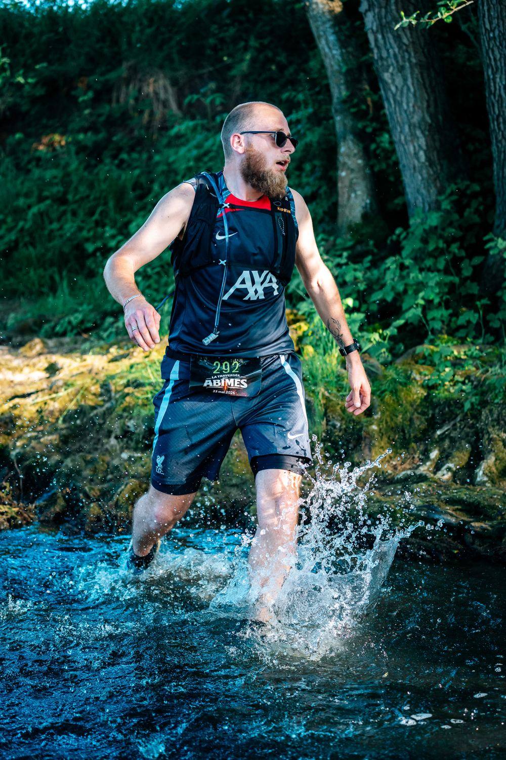 Un coureur traverse la rivière dans les éclaboussures